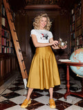 Woman in a gold skirt with a silver teapot in a library, wearing Plate XXI